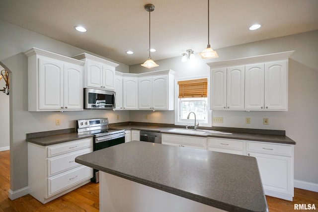 521 S French Dr, Dunlap, IL 61525 - kitchen featuring stainless steel appliances, dark countertops, white cabinets, light wood finished floors, and recessed lighting