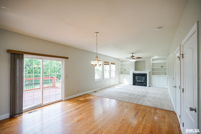 521 S French Dr, Dunlap, IL 61525 - unfurnished living room with a ceiling fan, a glass covered fireplace, light wood-style floors, and built in shelves
