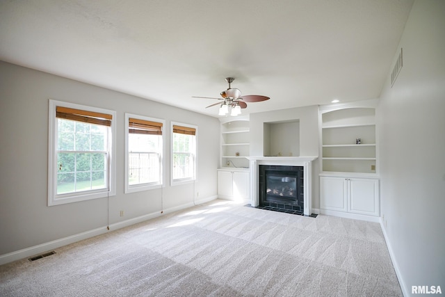 521 S French Dr, Dunlap, IL 61525 - unfurnished living room featuring carpet flooring, a ceiling fan, a fireplace, and built in shelves