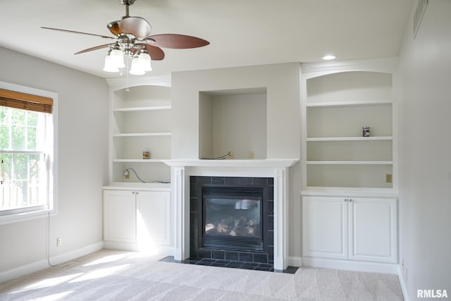 521 S French Dr, Dunlap, IL 61525 - unfurnished living room with a fireplace, built in shelves, a ceiling fan, and carpet floors