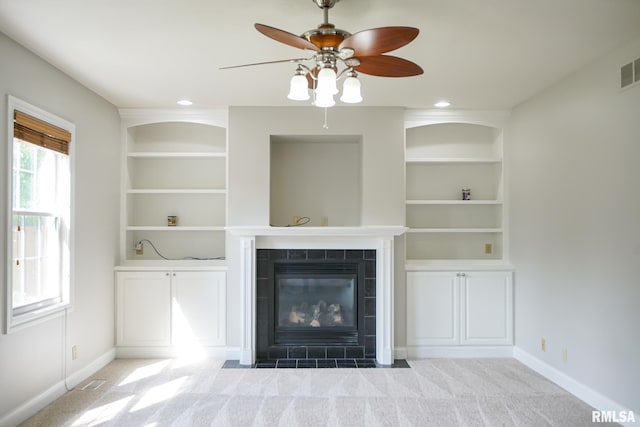 521 S French Dr, Dunlap, IL 61525 - unfurnished living room with a fireplace, ceiling fan, built in shelves, and carpet floors