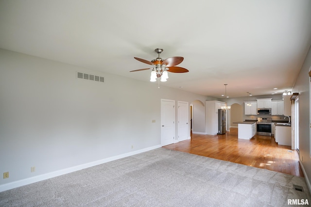 521 S French Dr, Dunlap, IL 61525 - unfurnished living room featuring arched walkways, light colored carpet, and ceiling fan