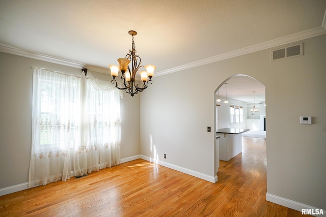 521 S French Dr, Dunlap, IL 61525 - empty room featuring arched walkways, a chandelier, light wood-style flooring, and ornamental molding