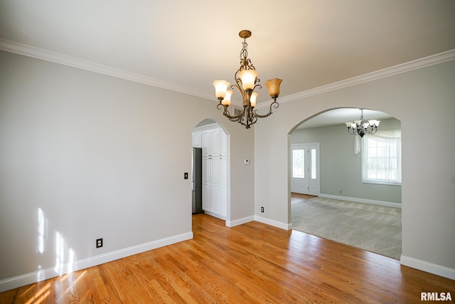521 S French Dr, Dunlap, IL 61525 - empty room with arched walkways, a chandelier, ornamental molding, and light wood finished floors