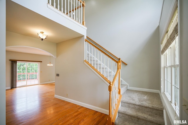 521 S French Dr, Dunlap, IL 61525 - stairway featuring arched walkways, wood finished floors, and a towering ceiling