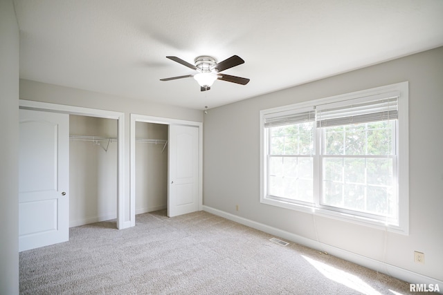 521 S French Dr, Dunlap, IL 61525 - unfurnished bedroom featuring multiple closets, light carpet, and ceiling fan