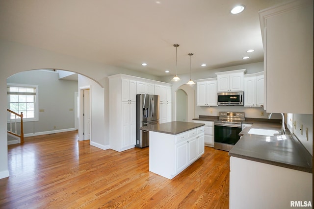 521 S French Dr, Dunlap, IL 61525 - kitchen with appliances with stainless steel finishes, arched walkways, dark countertops, recessed lighting, and a center island