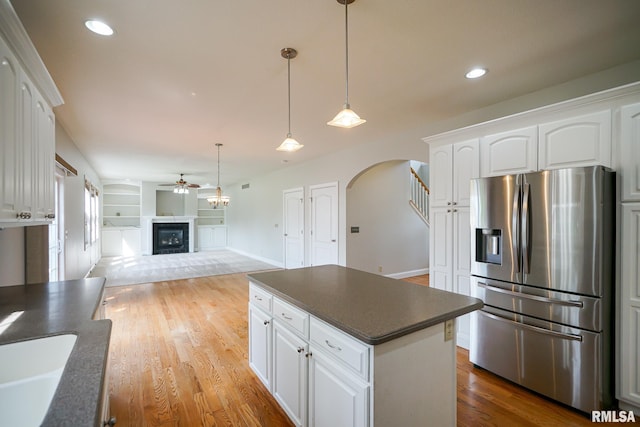 521 S French Dr, Dunlap, IL 61525 - kitchen with stainless steel fridge, arched walkways, dark countertops, a fireplace, and a ceiling fan
