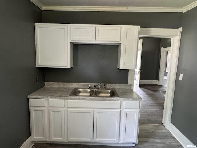 305 E Republic St, Peoria, IL 61603 - kitchen with a sink, crown molding, baseboards, and white cabinetry