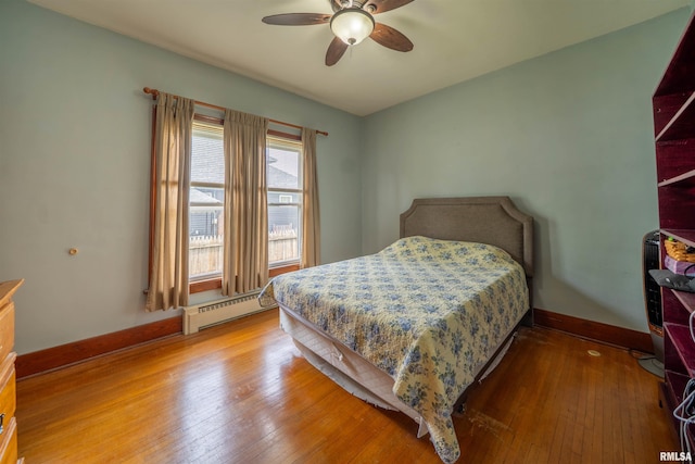 602 W Adams St, Abingdon, IL 61410 - bedroom featuring a baseboard heating unit, baseboards, hardwood / wood-style flooring, and a ceiling fan