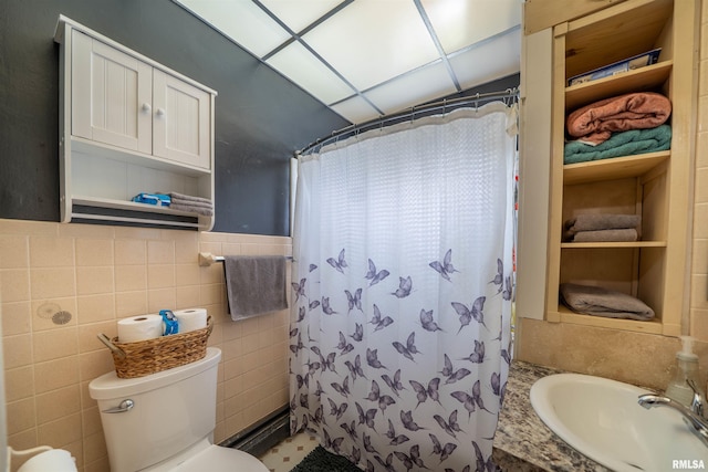 602 W Adams St, Abingdon, IL 61410 - full bath with tile walls, a sink, toilet, a shower with curtain, and a wainscoted wall
