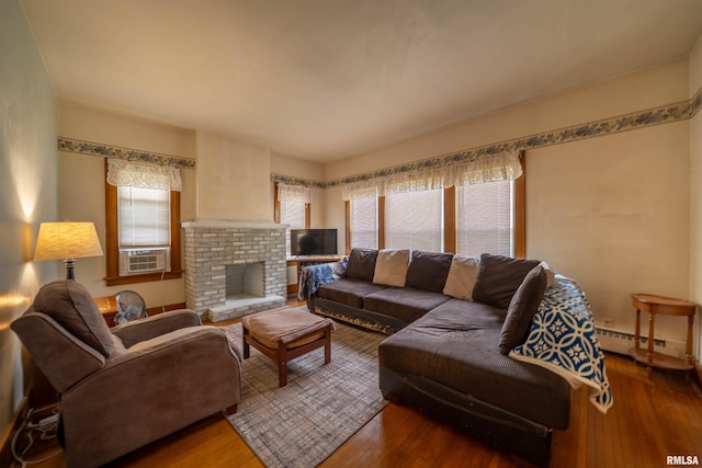 602 W Adams St, Abingdon, IL 61410 - living area featuring wood finished floors, cooling unit, baseboard heating, and a brick fireplace
