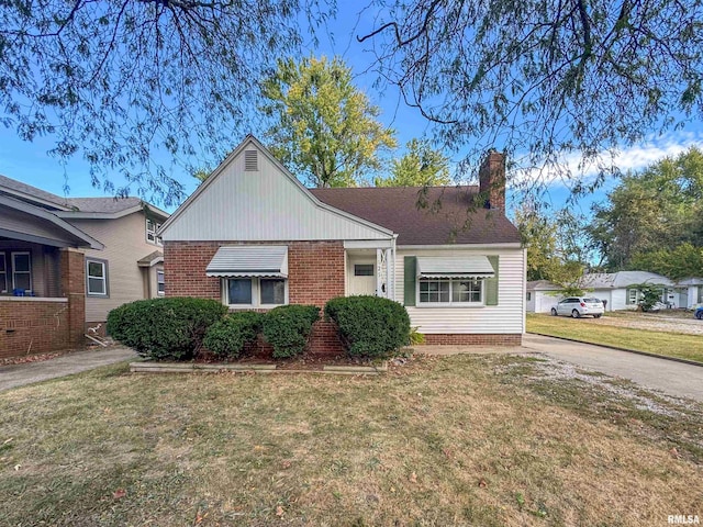 1025 E Corrington Ave, Peoria, IL 61603 - bungalow-style house with a front lawn, a chimney, brick siding, and concrete driveway