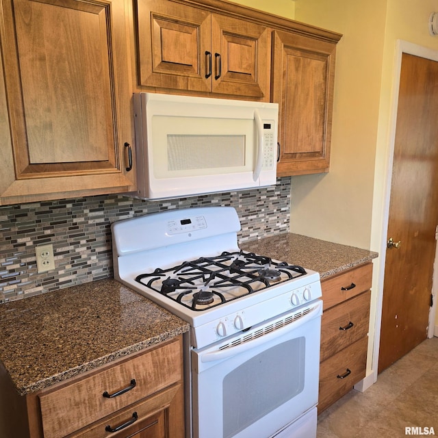 4928 W Farmington Rd, Peoria, IL 61604 - kitchen featuring white appliances, brown cabinets, backsplash, and dark stone countertops