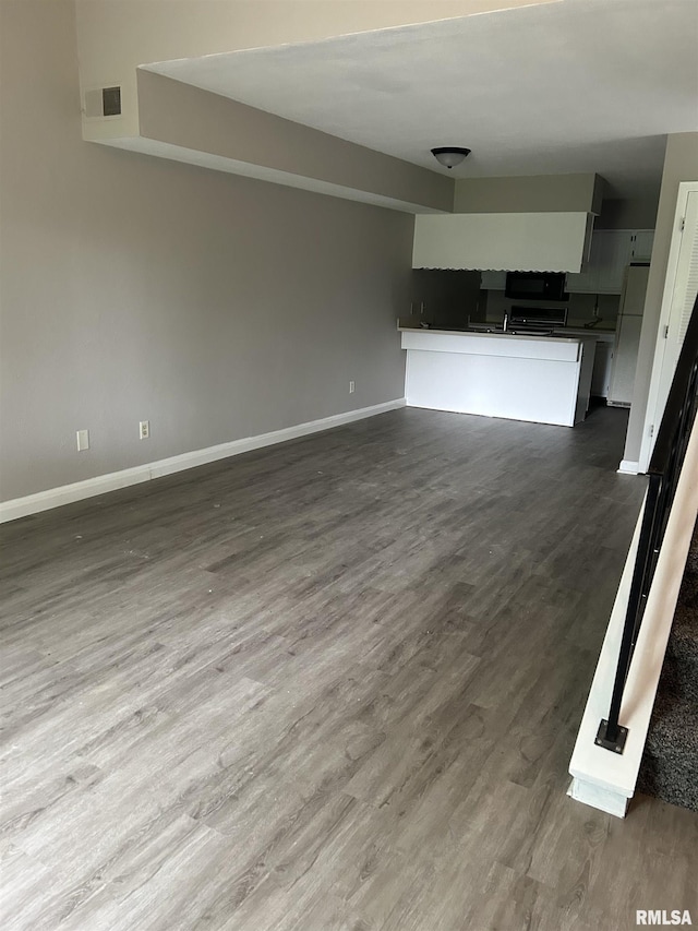6831 N Frostwood Pkwy Unit D29, Peoria, IL 61615 - unfurnished living room featuring baseboards and dark wood-style flooring