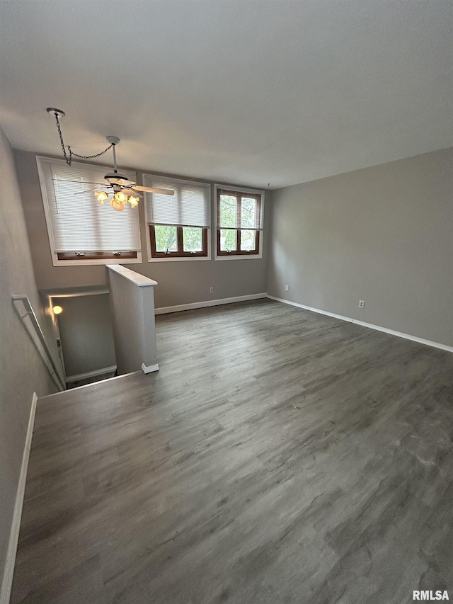 6831 N Frostwood Pkwy Unit D29, Peoria, IL 61615 - unfurnished living room featuring baseboards and dark wood-type flooring