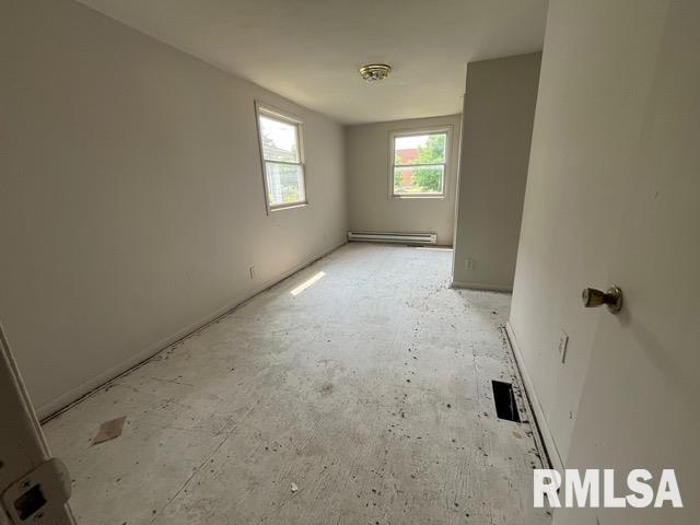 907 E Republic St, Peoria, IL 61603 - spare room featuring a baseboard heating unit