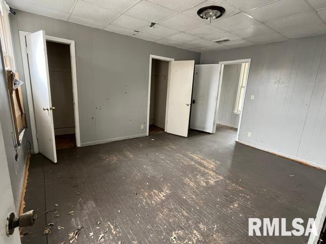 907 E Republic St, Peoria, IL 61603 - unfurnished bedroom with wood finished floors and a paneled ceiling