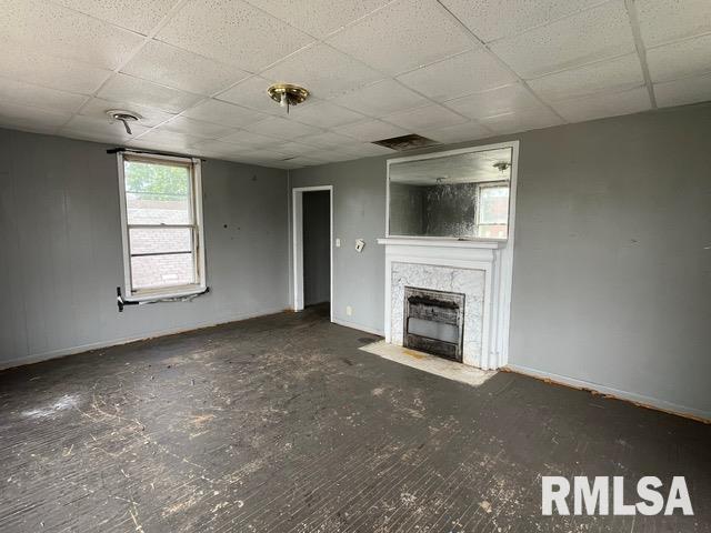 907 E Republic St, Peoria, IL 61603 - unfurnished living room featuring a drop ceiling and a fireplace