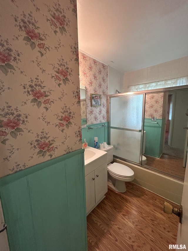 1407 Lincoln St, Pekin, IL 61554 - bathroom with wallpapered walls, wood finished floors, vanity, enclosed tub / shower combo, and wainscoting
