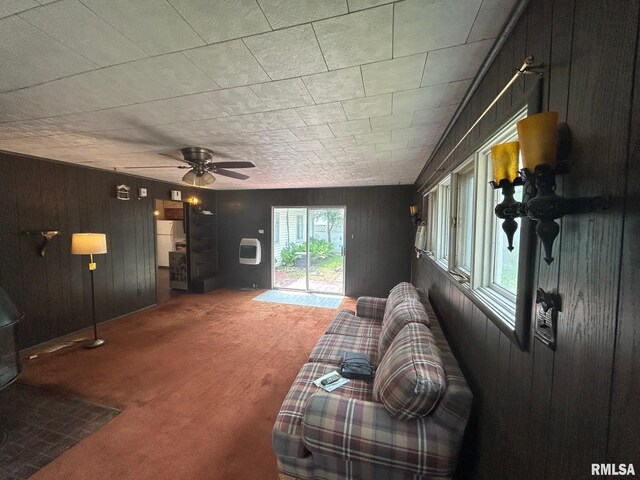 1407 Lincoln St, Pekin, IL 61554 - living room with wood walls, carpet flooring, and a ceiling fan