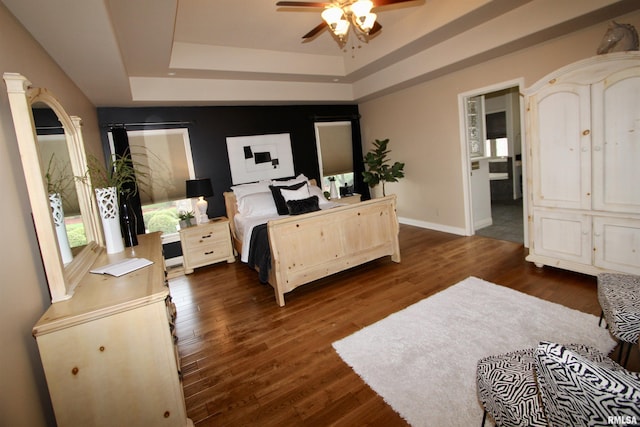 1964 Chestnut Ln, Washington, IL 61571 - bedroom featuring a tray ceiling, dark wood-style flooring, and a ceiling fan