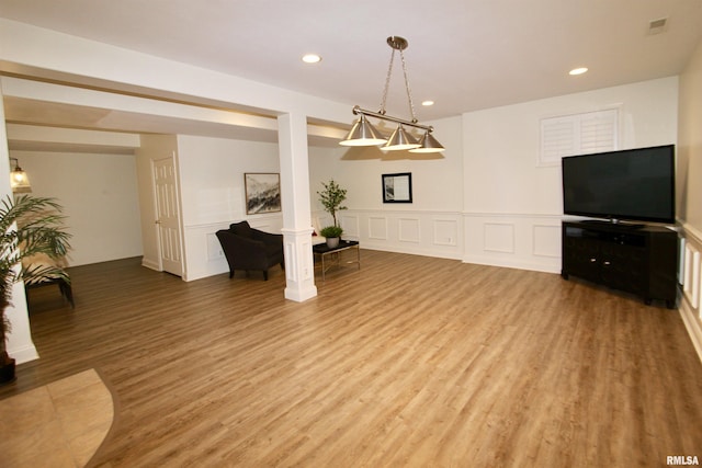 1964 Chestnut Ln, Washington, IL 61571 - unfurnished living room featuring light wood finished floors, a decorative wall, recessed lighting, a wainscoted wall, and ornate columns