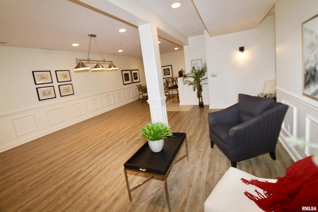 1964 Chestnut Ln, Washington, IL 61571 - living room featuring wood finished floors, wainscoting, recessed lighting, ornate columns, and a decorative wall