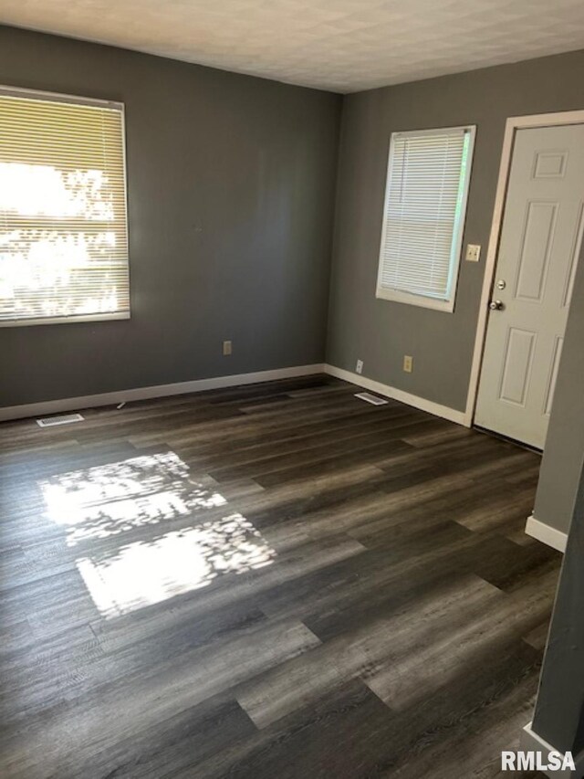 102 Main St, Camp Grove, IL 61424 - empty room with baseboards and dark wood-type flooring
