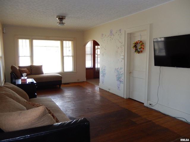120 W Adams St, Macomb, IL 61455 - living area featuring arched walkways, wood finished floors, and a textured ceiling