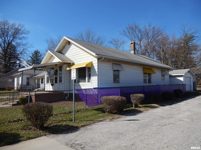 120 W Adams St, Macomb, IL 61455 - view of front facade with a fenced front yard, a chimney, and an outdoor structure