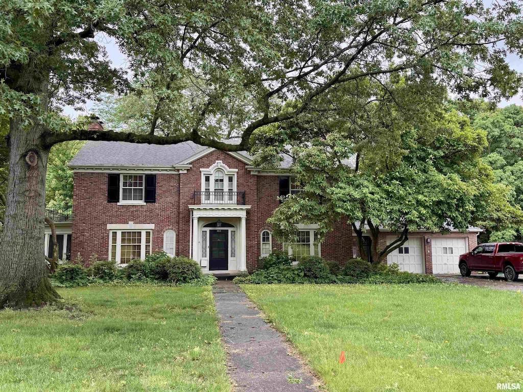 360 N Normal St, Macomb, IL 61455 - colonial inspired home featuring a front yard, brick siding, and a garage