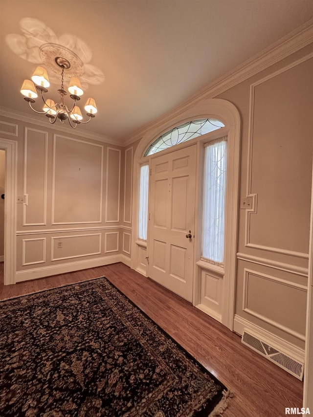 360 N Normal St, Macomb, IL 61455 - foyer entrance featuring a decorative wall, wood finished floors, a chandelier, and crown molding