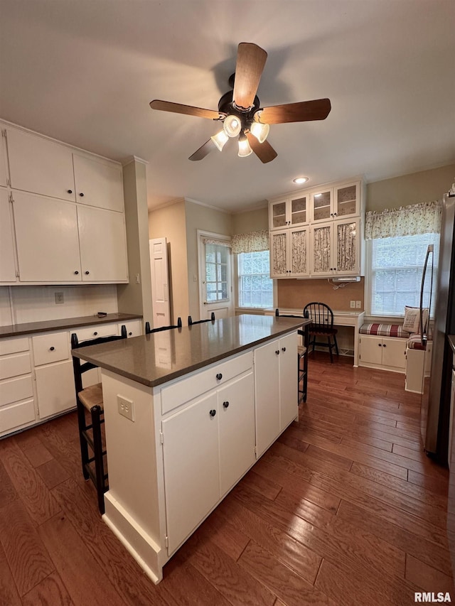 360 N Normal St, Macomb, IL 61455 - kitchen with dark countertops, dark wood-type flooring, a center island, white cabinetry, and a kitchen bar
