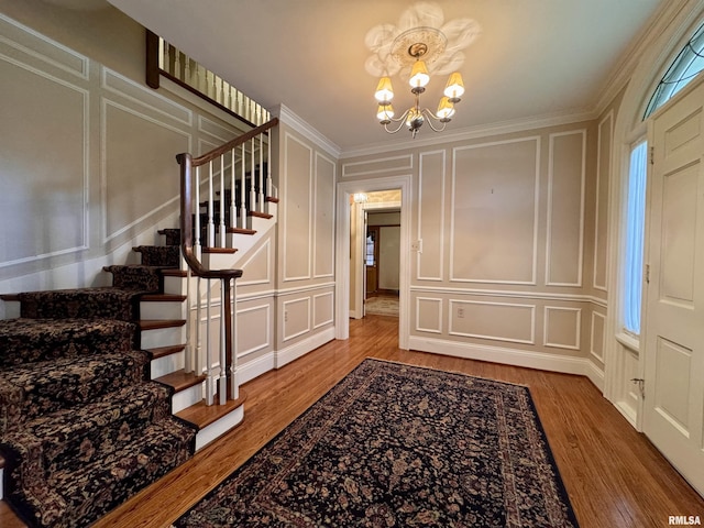 360 N Normal St, Macomb, IL 61455 - foyer featuring a decorative wall, a chandelier, wood finished floors, stairway, and ornamental molding