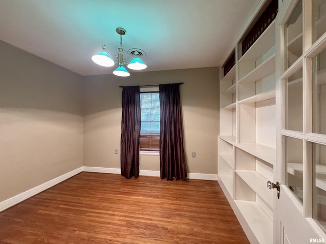 360 N Normal St, Macomb, IL 61455 - empty room featuring wood finished floors and a chandelier
