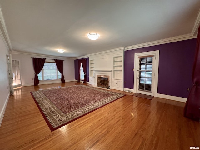 360 N Normal St, Macomb, IL 61455 - unfurnished living room featuring ornamental molding, wood finished floors, built in shelves, and a fireplace
