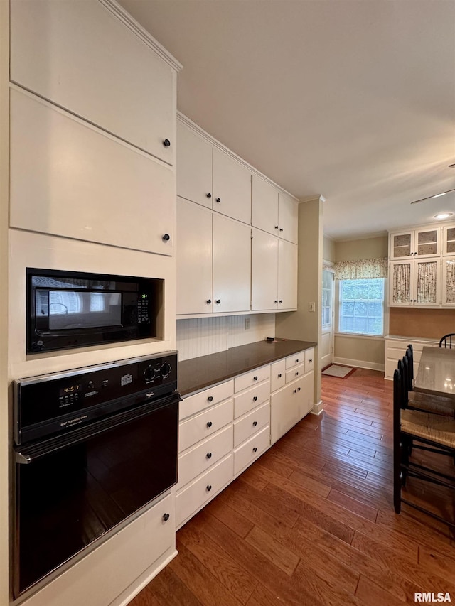 360 N Normal St, Macomb, IL 61455 - kitchen with black appliances, dark wood-type flooring, white cabinetry, and dark countertops