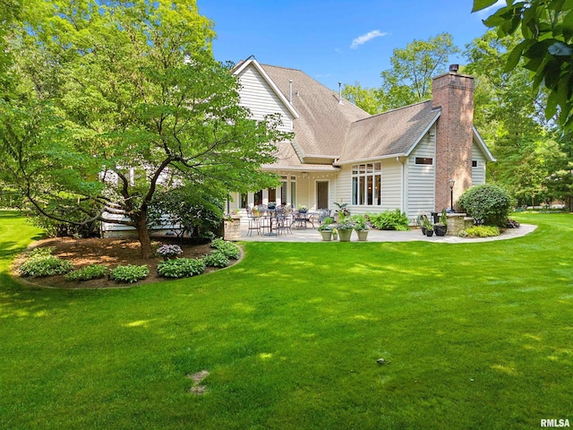 11518 N Nettle Creek Dr, Dunlap, IL 61525 - back of house featuring a patio area, a lawn, a shingled roof, and a chimney