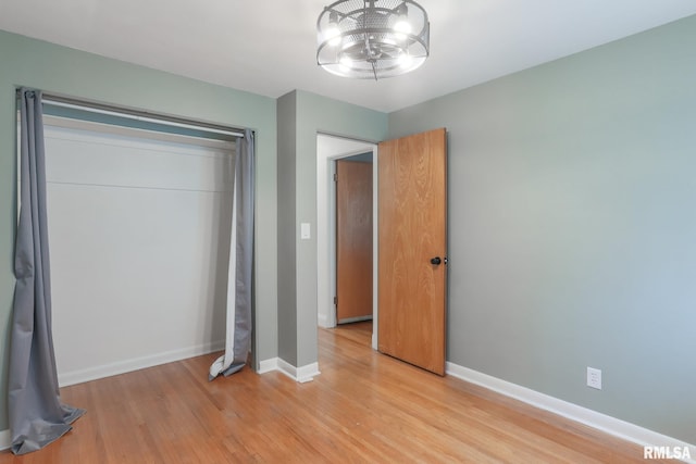 4415 N Rosemead Dr, Peoria, IL 61614 - unfurnished bedroom featuring light wood finished floors and a chandelier