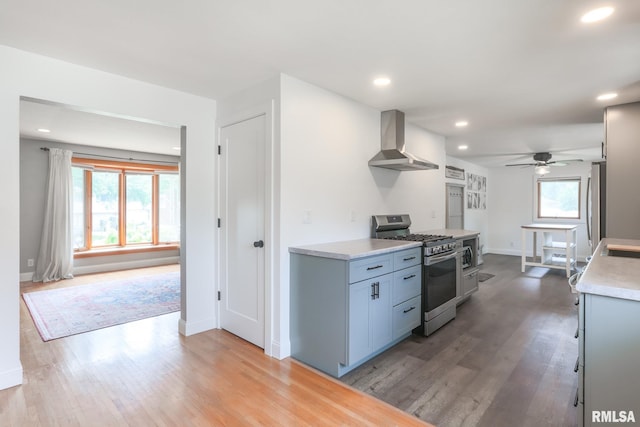 4415 N Rosemead Dr, Peoria, IL 61614 - kitchen with appliances with stainless steel finishes, wall chimney range hood, ceiling fan, light countertops, and light wood-type flooring