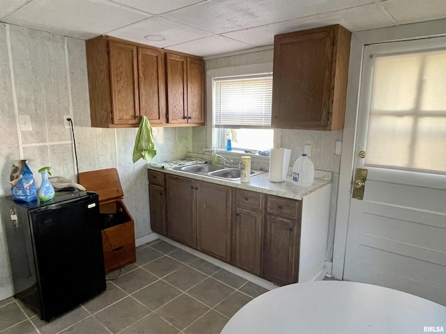 665 W Wilmot St, Chillicothe, IL 61523 - kitchen with a sink, refrigerator, dark tile patterned floors, light countertops, and brown cabinetry