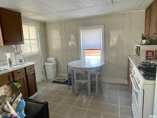 665 W Wilmot St, Chillicothe, IL 61523 - kitchen featuring gas range gas stove, tile patterned flooring, brown cabinets, and light countertops
