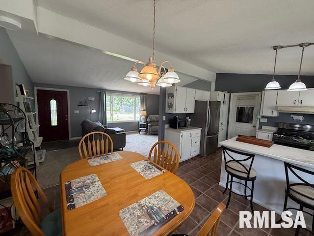 603 Sherry St, Colchester, IL 62326 - dining area featuring lofted ceiling, a chandelier, and dark tile patterned floors