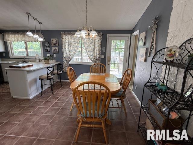 603 Sherry St, Colchester, IL 62326 - dining area featuring a chandelier, dark tile patterned flooring, and baseboards