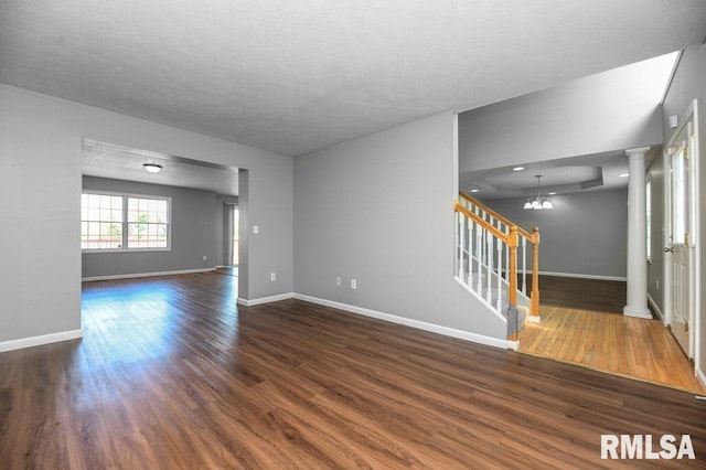 2331 W Molly Ln, Dunlap, IL 61525 - unfurnished room featuring dark wood-type flooring, stairway, a chandelier, baseboards, and a textured ceiling