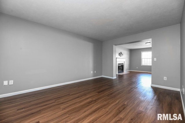 2331 W Molly Ln, Dunlap, IL 61525 - unfurnished living room with dark wood-style floors, baseboards, and a fireplace with flush hearth