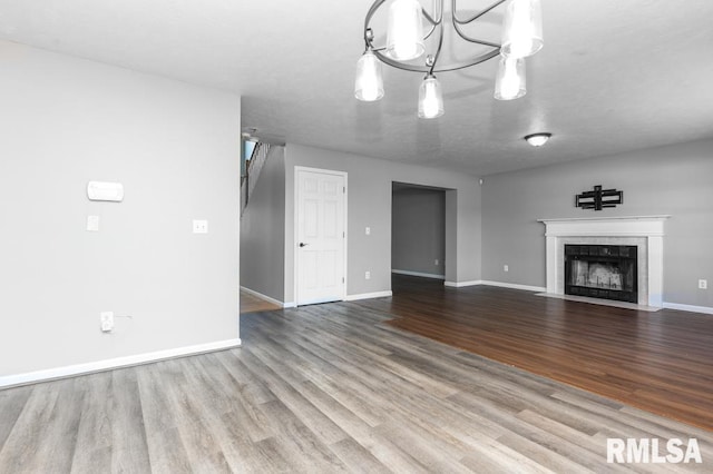 2331 W Molly Ln, Dunlap, IL 61525 - unfurnished living room featuring wood finished floors, baseboards, and a tile fireplace