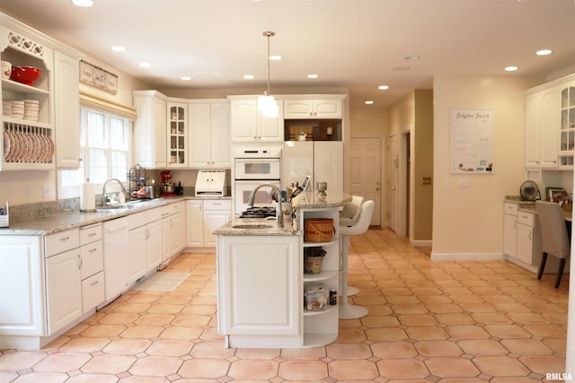1112 W Cedar Hills Dr, Dunlap, IL 61525 - kitchen featuring open shelves, a center island, white appliances, recessed lighting, and glass insert cabinets