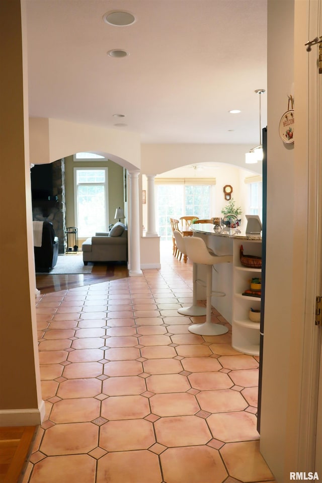 1112 W Cedar Hills Dr, Dunlap, IL 61525 - corridor featuring arched walkways, plenty of natural light, ornate columns, recessed lighting, and light tile patterned floors